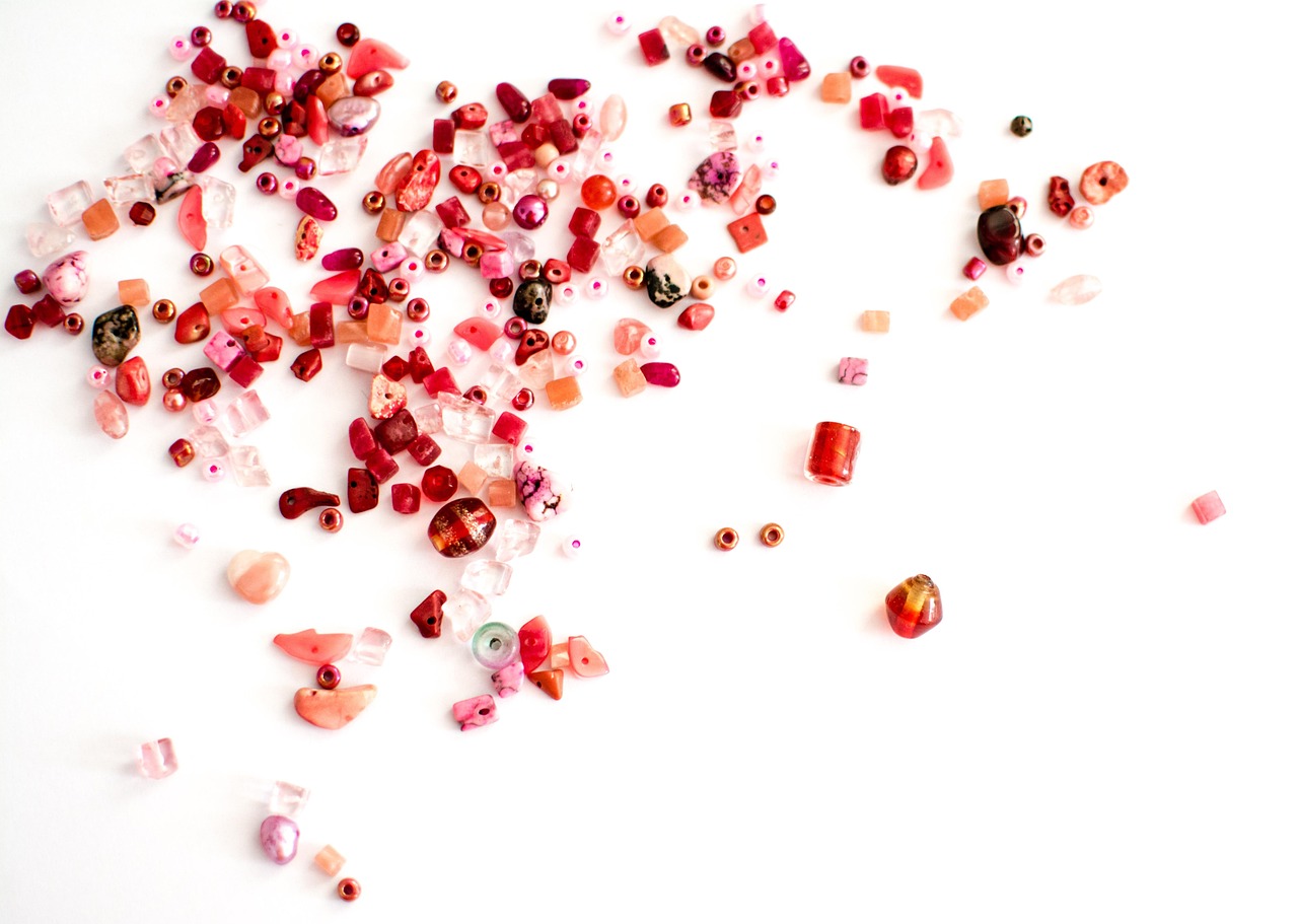 Donkere nagellak naast bordeauxrode sieraden op tafel. Donkere nagellak naast bordeauxrode sieraden op tafel.
